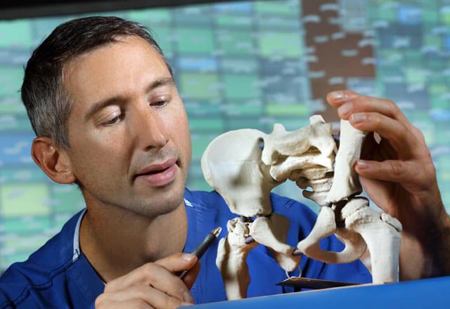 orthopaedic surgeon looking at bone model